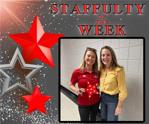 A woman in red holds a red and white star as she poses with a woman in yellow.